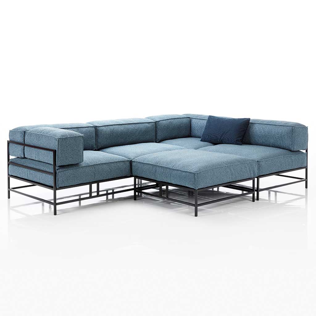 brühl easy pieces 62023 + 62023 L-förmige Garnitur mit blauen Polstern und schwarzem Metallgestell. Vor den mittleren Sitzplatz ist ein passender Hocker angestellt.