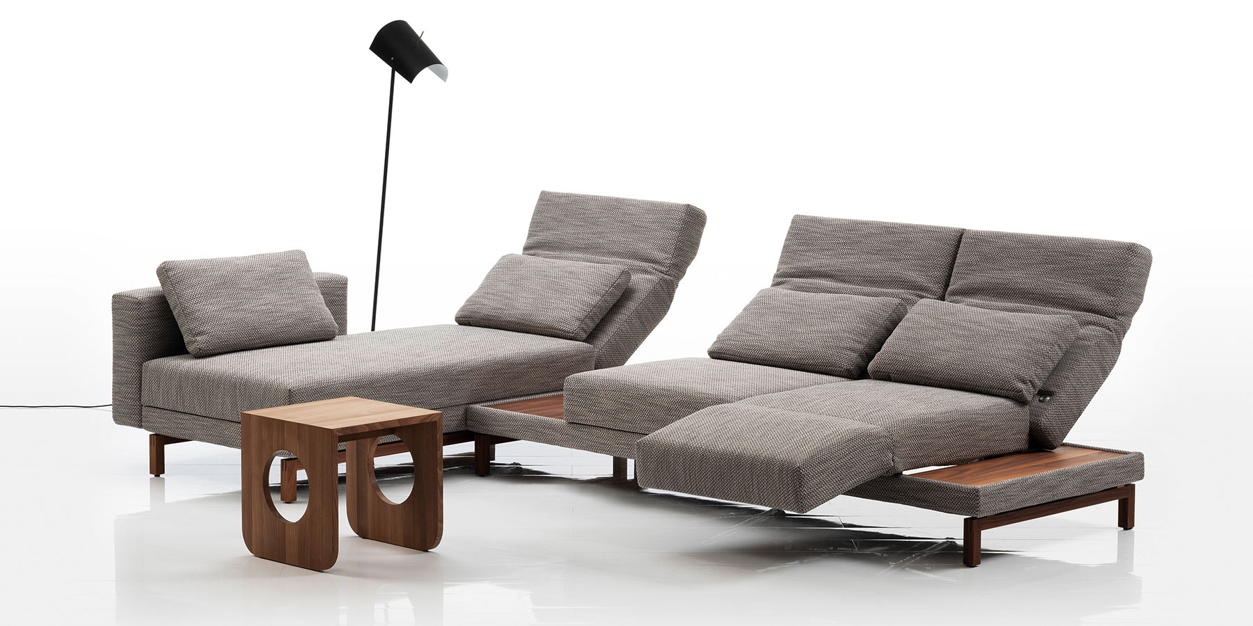 Sofas und Eckgarnituren von brühl moule small Eine Eckgarnitur bestehend aus einem Longchair und einem Anstellsofa. Der Stoff ist milchkaffebraun, das Gestell ist aus dunklem Holz.