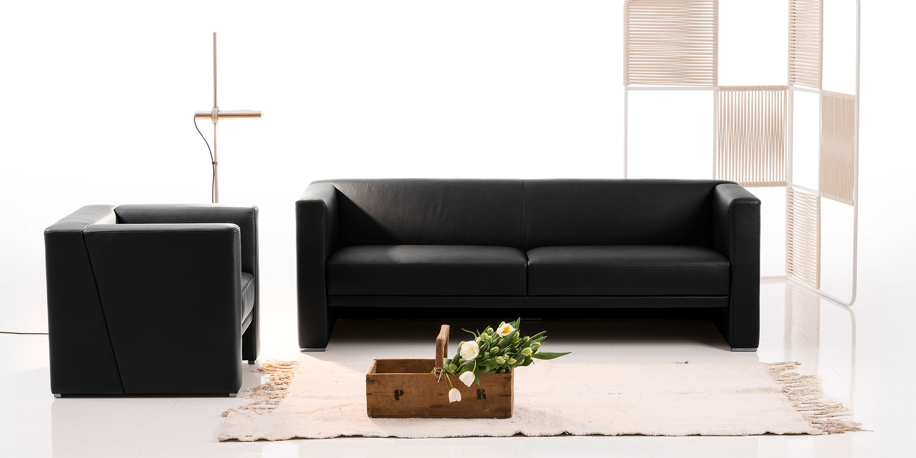 Sofas und Sessel brühl visavis Ein schwarzer Ledersessel und ein schwarzes Ledersofa.