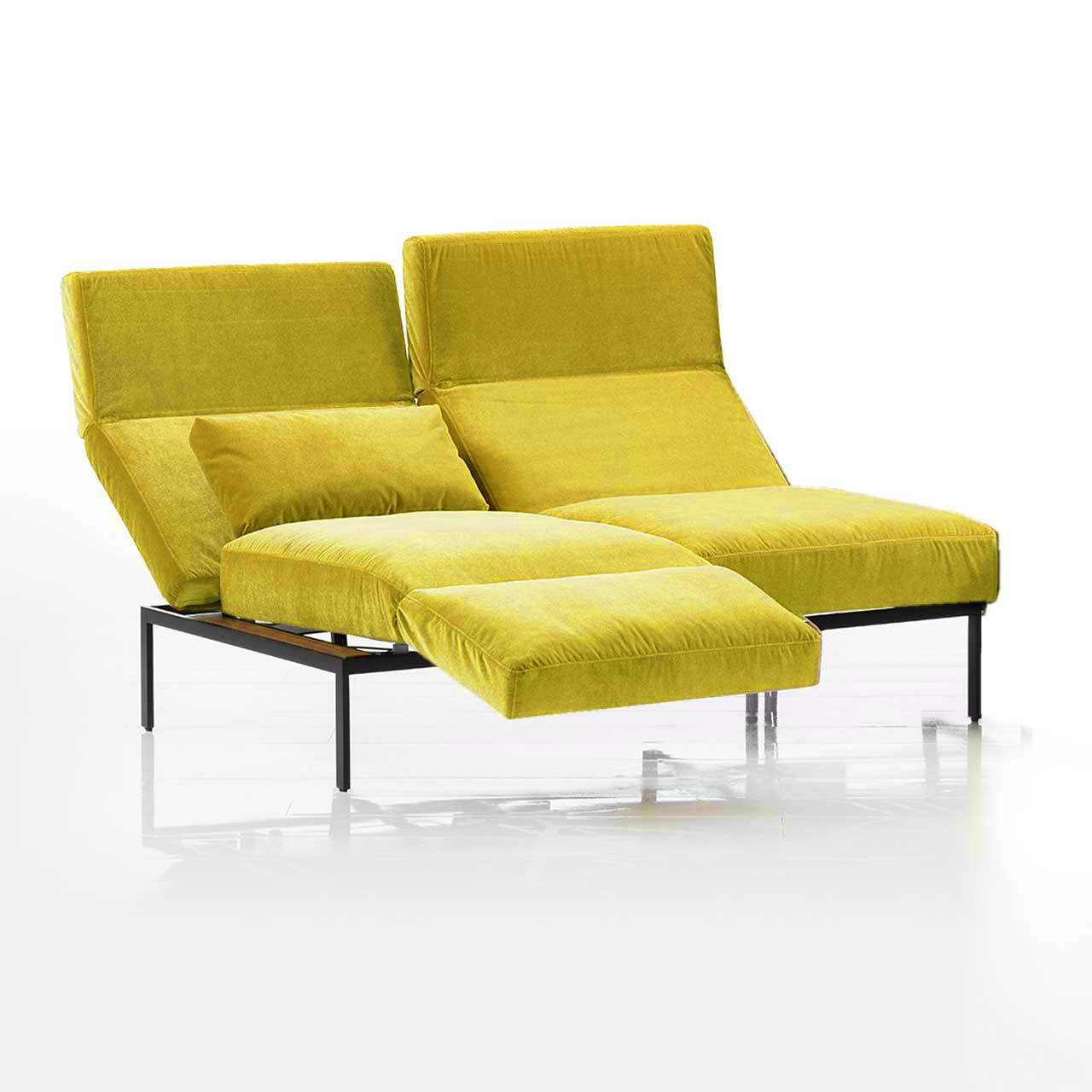 Anstellsofa brühl roro medium spring 73906 Das Anstellsofa der Serie roro medium spring mit zwei Sitzplätzen in gelbem Stoff. Die Rücken sind leicht abgesenkt, die Armlehne auf der linken Seite ist als Fußstütze vorgeschwenkt.