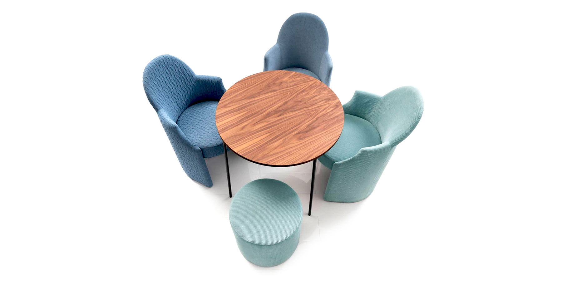 Drei Sessel mit runder Sitzbasis und ein runder Hocker stehen um einen runden Holztisch. Der Hintergrund ist weiß. Die Sessel sind blau, ein weiterer Sessel und der Hocker sind türkis.