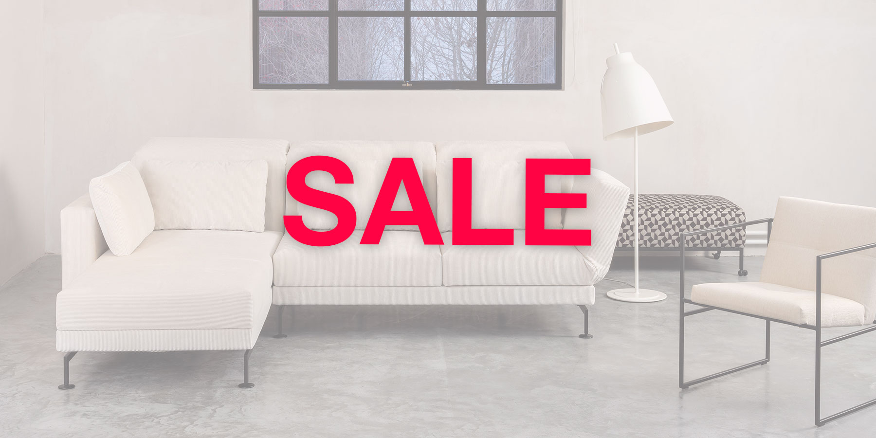 brühl Sale Ein cremefarbenes Ecksofa. Im Vordergrund steht in roter Schrift "Sale"