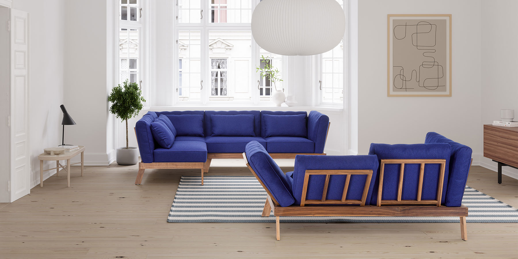 Sofas brühl lofoten pure und lofoten lounge Eine Eckarnitur und ein Sofa stehen einander leicht schräg versetzt gegenüber. Die aufgelegten Polster sind dunkelblau, das Holzgestell aus heller Eiche.
