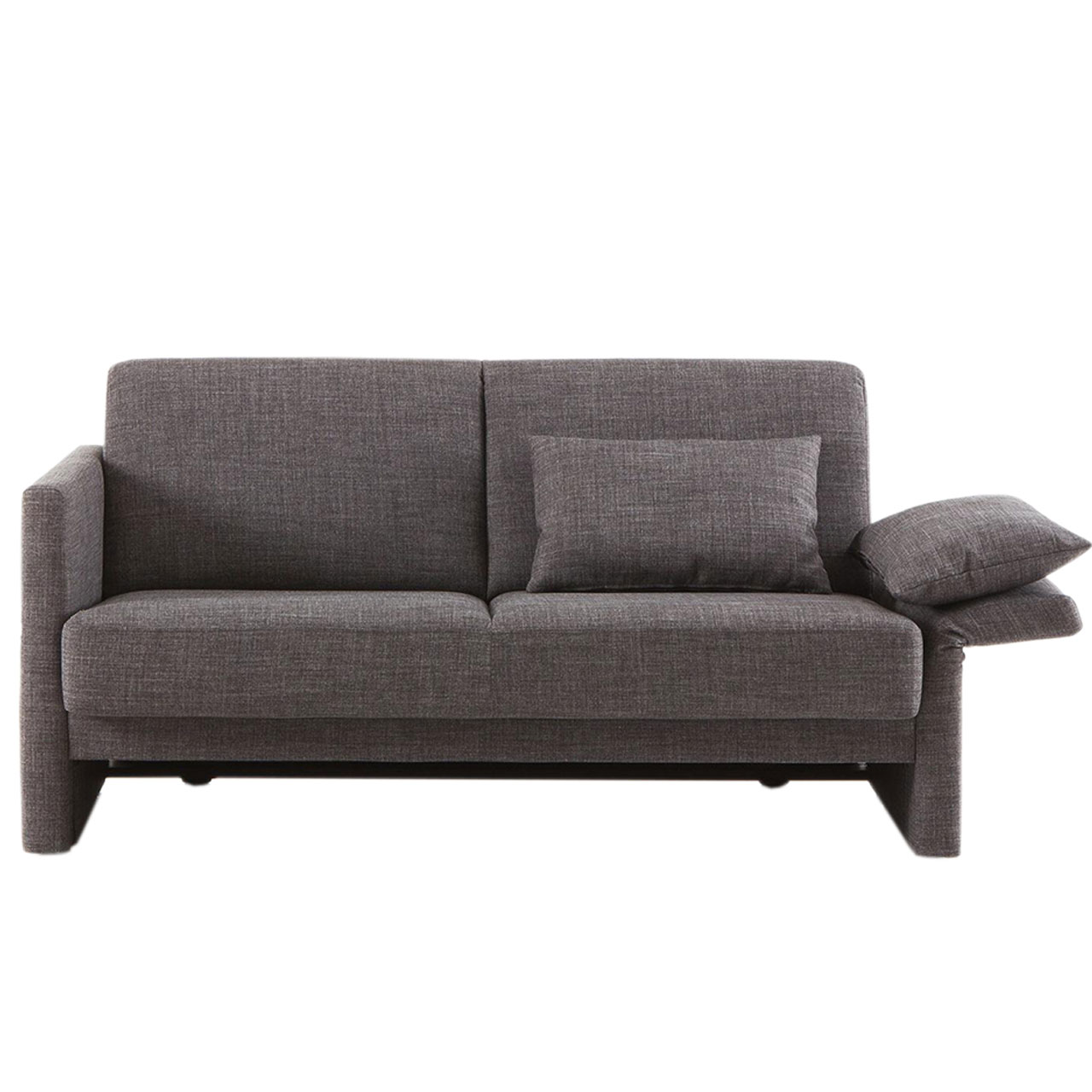 Ein braunes Sofa mit abgewinkelter Armlehne auf der rechten Seite. Auf dieser liegt eines der Rückenkissen wie ein Kopfkissen. Das zweite Rückenkissen ist an die Rückenlehne gelehnt.