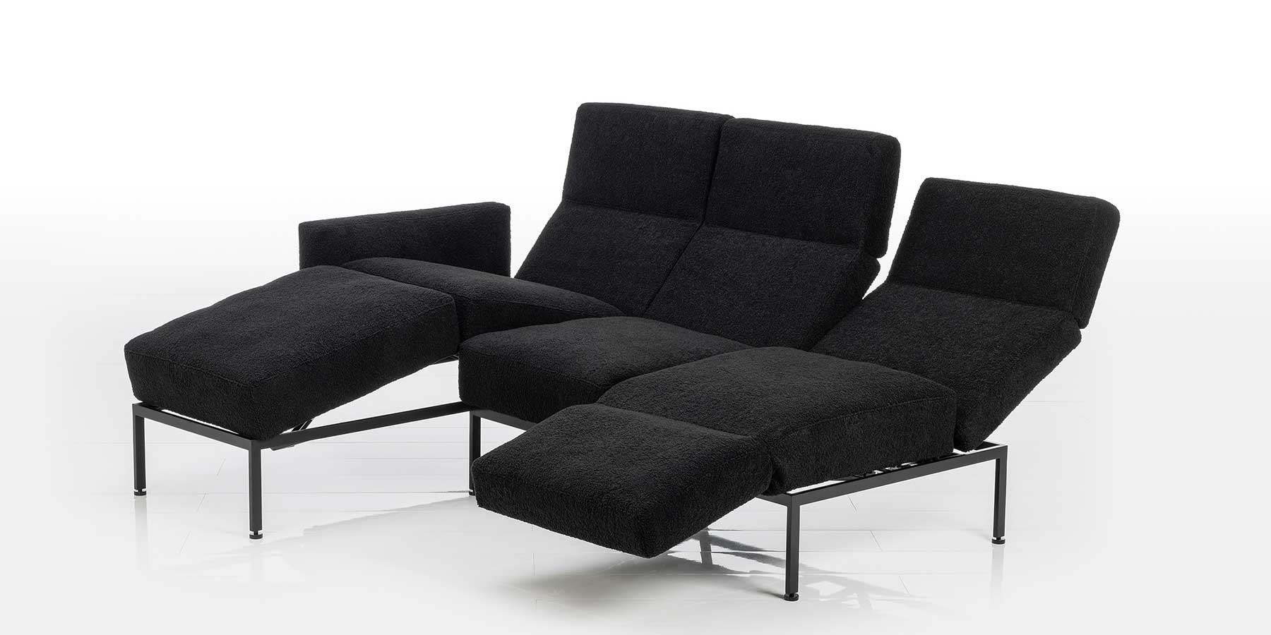 Kategorie roro small soft Kombination aus Longchair und Anstellsofa in schwarzem Stoff. Die Sitzplätze sind in verschiedene Relaxpositionen eingestellt.