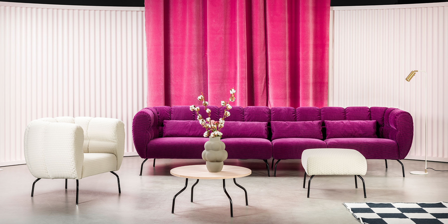 Polstermöbel brühl magnolia Ein Sessel und ein Sofa stehen im rechten Winkel zueinander. Das Gestell der Polstermöbel sind filigrane, gebogene, schwarze Metallfüße. Die Polster der Möbel sind opulent und umschließen die Sitzbasis ganz.